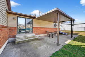 View of patio with outdoor dining space and entry steps