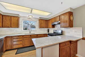 Kitchen with wood finish cabinets, a peninsula, and light quartz countertops