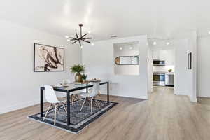Dining area featuring light wood-type flooring and hanging lights