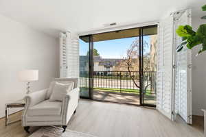 Living area with floor to ceiling windows and light wood-style flooring