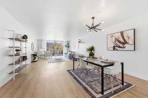 Dining space with light wood-style floors, hanging lights, and expansive windows
