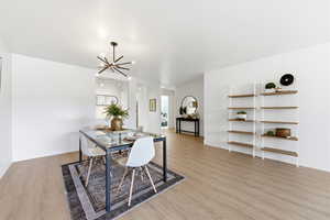 Dining room with light wood finished floors and hanging lights