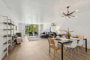 Dining space featuring expansive windows, light wood finished floors, and a chandelier