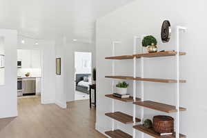 Hallway with light wood-type flooring and baseboards