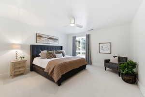 Bedroom with light colored carpet and a ceiling fan