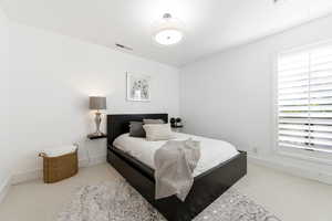 Bedroom featuring light colored carpet