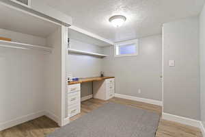 Unfurnished office featuring a textured ceiling and light wood-style flooring