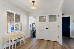 Foyer with light wood-type flooring and baseboards