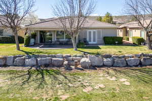 Back of house with stucco siding, a tile roof, a yard, and a patio area