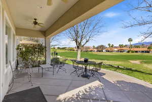 View of patio / terrace with a ceiling fan, a residential view, outdoor dining area, and golf course view