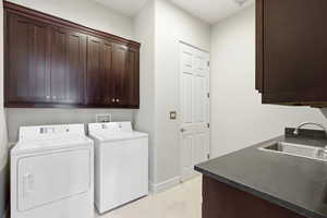 Laundry room featuring cabinet space, washing machine and clothes dryer, and light tile patterned floors