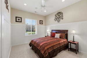 Bedroom with wainscoting, light carpet, a ceiling fan, and recessed lighting