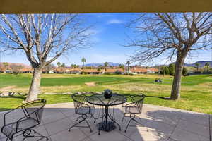 View of patio with a mountain view, a residential view, outdoor dining space, and view of golf course