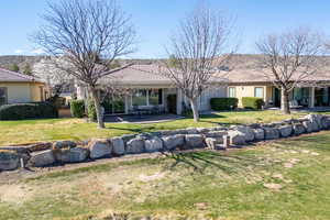 Rear view of house featuring a patio, stucco siding, a lawn, and a tile roof
