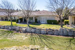 Back of property with a patio area, stucco siding, french doors, and a lawn