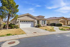 Mediterranean / spanish home with stucco siding, an attached garage, driveway, and a front yard