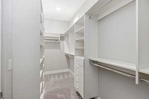 Walk in closet with light carpet