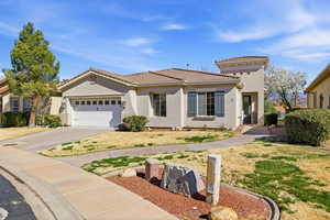 Mediterranean / spanish-style house with stucco siding, driveway, an attached garage, a tile roof, and a front yard