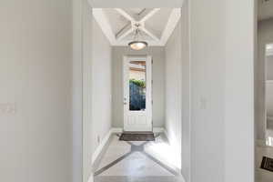 Entrance foyer featuring inlaid floor details, coffered ceiling, and light tile patterned floors
