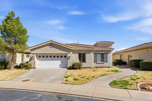 Mediterranean / spanish-style house with stucco siding, an attached garage, concrete driveway, and a tile roof