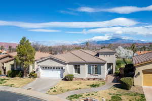 Mediterranean / spanish-style house with stucco siding, a mountain view, an attached garage, a tiled roof, and driveway