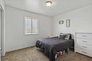 Bedroom featuring carpet floors and baseboards