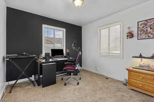 Home office with baseboards and light carpet
