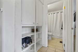 Full bathroom featuring light tile patterned flooring and a closet