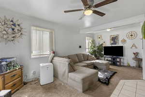 Living area with carpet flooring, crown molding, ceiling fan, and plenty of natural light