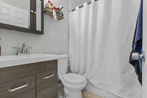 Bathroom with a shower with shower curtain and vanity