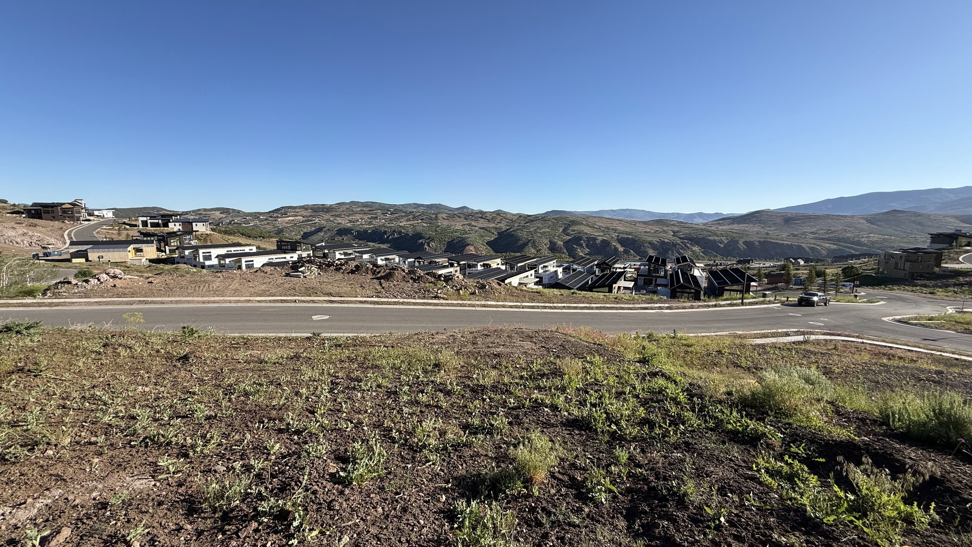 Expansive land parcel featuring existing road infrastructure and distant mountain ranges