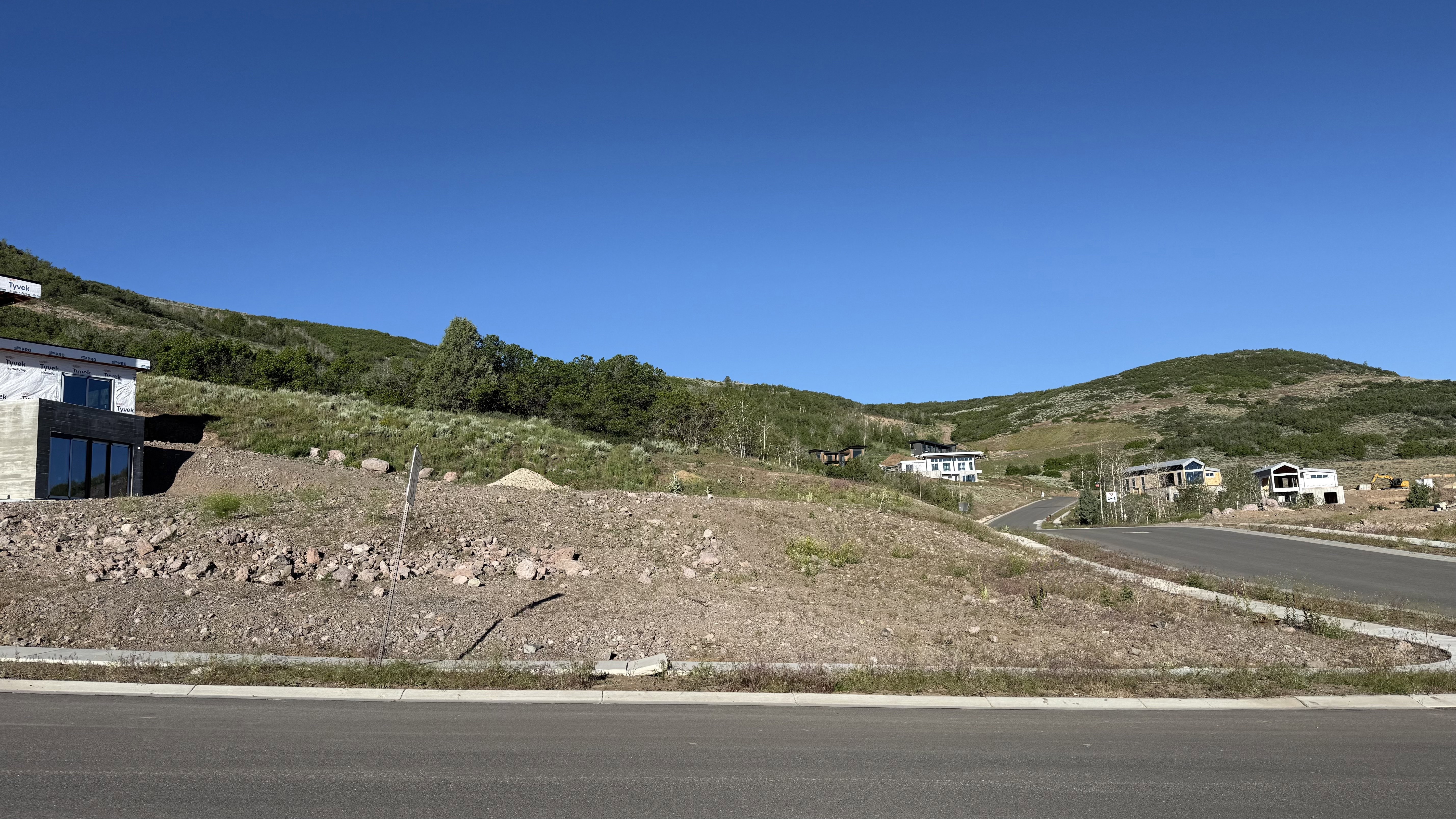 Expansive uphill lot with a paved road frontage, offering a clear view of the surrounding hills