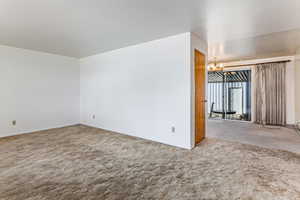 Spare room featuring carpet floors and suspended lighting