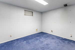 Carpeted spare room with baseboards