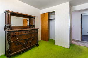 Bedroom featuring carpet flooring and a closet