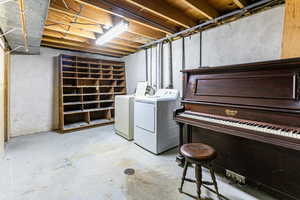 Unfinished below grade area with washing machine and dryer