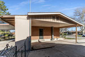 View of building exterior with an attached carport and concrete driveway