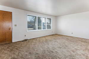 Unfurnished room with carpet and baseboards Hardwood floors are underneath carpet