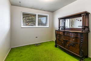 Bedroom featuring carpet and baseboards