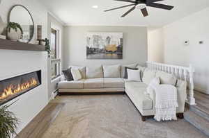 Living area featuring crown molding, a ceiling fan, recessed lighting, a large fireplace, and a baseboard heating unit