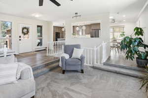 Living area with ceiling fan, ornamental molding, wood finished floors, a baseboard heating unit, and recessed lighting
