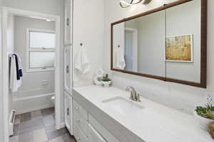 Full bath with vanity and baseboard heating