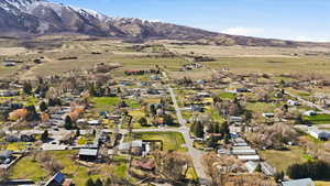 Aerial overview of property's location with nearby suburban area, a mountainous background, and rural landscape