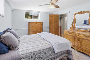 Bedroom with ceiling fan and light colored carpet