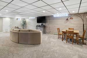 Living room with light colored carpet, a paneled ceiling, and recessed lighting