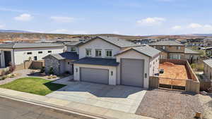 View of front of home with stucco siding, a gate, driveway, a residential view, and an attached garage