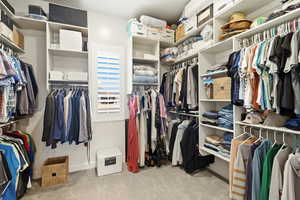 Walk in closet with light colored carpet