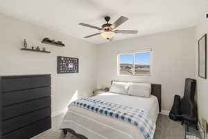 Carpeted bedroom featuring a ceiling fan and baseboards