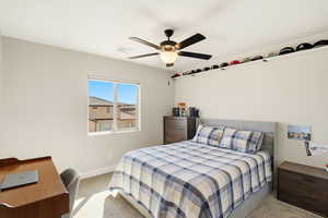 Bedroom with light colored carpet and a ceiling fan