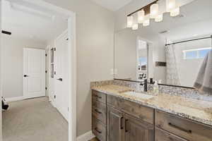 Full bath with vanity, a shower with shower curtain, and light carpet